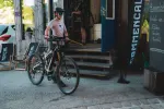 Person mit einem Fahrrad in der Nähe eines Geschäftseingangs
