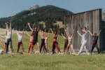 Gruppe von Menschen, die im Freien Yoga machen, in schöner Landschaft