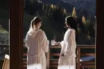 Zwei Frauen in Bademänteln genießen die Aussicht von einem Balkon