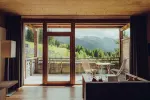 Gemütlicher Innenraum mit Blick auf die Berge durch große Fenster
