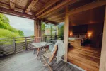 Holzterrasse mit Tisch und Stuhl, Blick auf die Natur