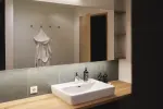 Modernes Badezimmer mit Waschbecken, Holzarbeitsplatte und Spiegel