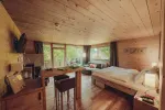gemütliches Schlafzimmer mit Holzdekor und großen Fenstern
