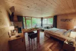Holzschlafzimmer mit großen Fenstern und natürlichem Licht