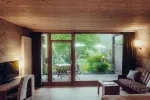 gemütliches Wohnzimmer mit Holzdecke und Blick auf die Terrasse