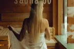 Person in der Sauna, mit Handtuch umwickelt, Rückansicht