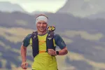 Läufer in Berglandschaft, trägt ein gelbes Shirt