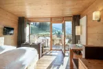 Holzhotelzimmer mit großen Fenstern und Bergblick
