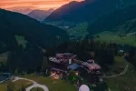 Luftaufnahme eines Tals bei Sonnenuntergang mit Bergen
