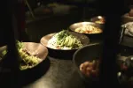 Schalen mit verschiedenen Gerichten auf einem dunklen Tisch