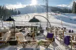 Sonnenliegen in einer verschneiten Landschaft mit Bergen im Hintergrund