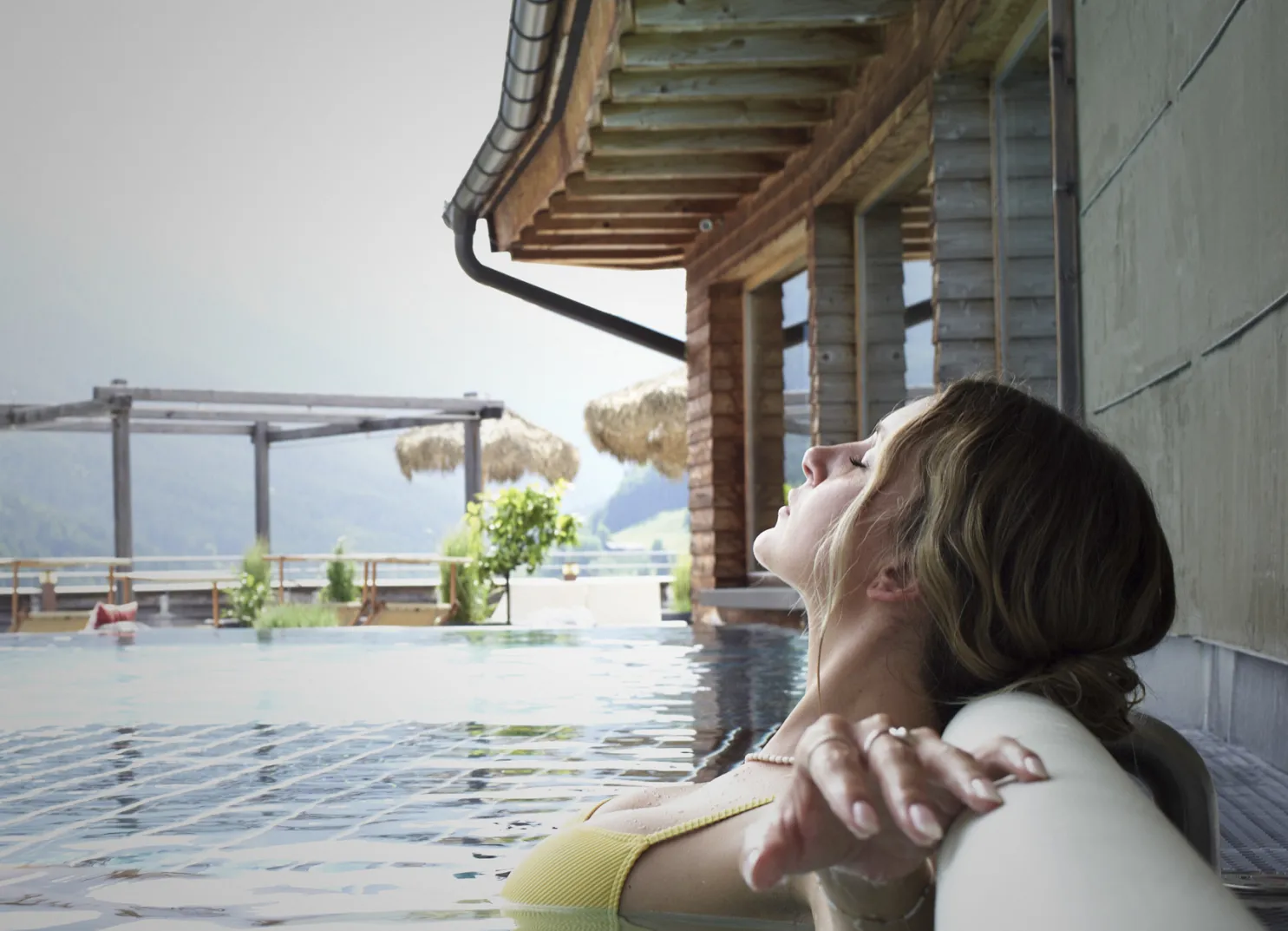 Frau im Pool vor winterlicher Kulisse