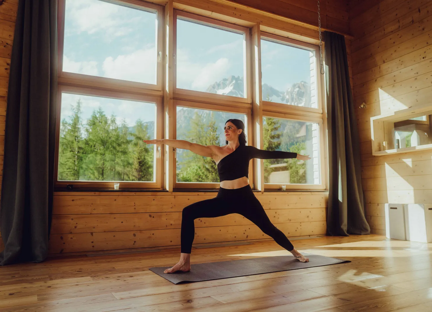 Frau praktiziert Yoga vor Bergkulisse