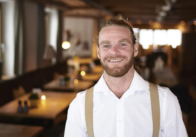 Mann mit Lächeln in einem Holzhotel-Restaurant