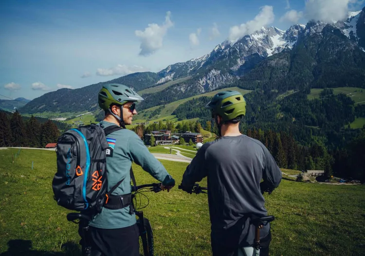 Zwei Radfahrer blicken auf die Berge und die Landschaft.