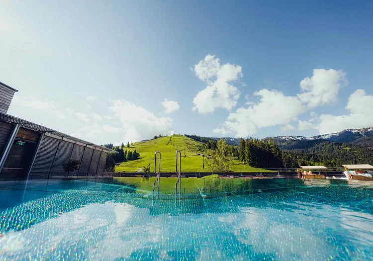 Pool mit Blick auf bewaldete Hügel und blauen Himmel