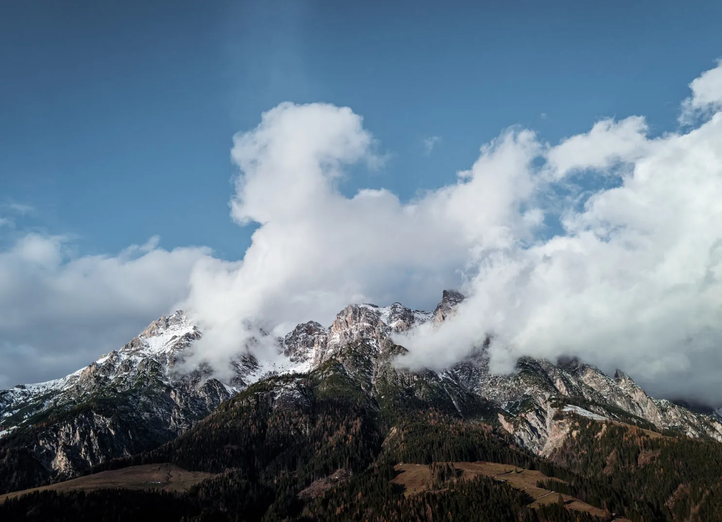 Berglandschaft mit Wolken und schneebedeckten Gipfeln