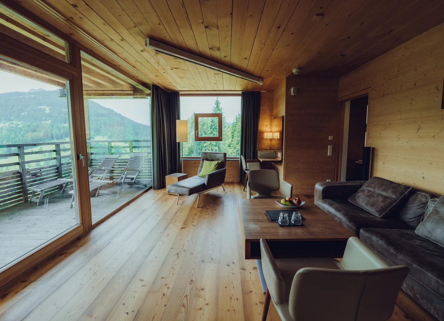 Heller Wohnraum mit Holzdecken und Blick auf die Berge.