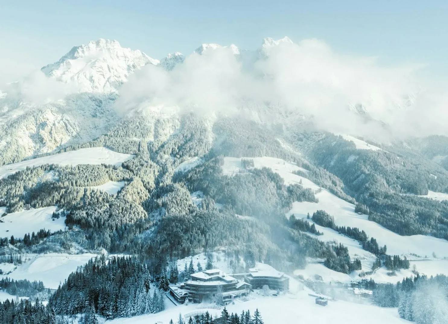 Hotel vor winterlicher Bergkulisse