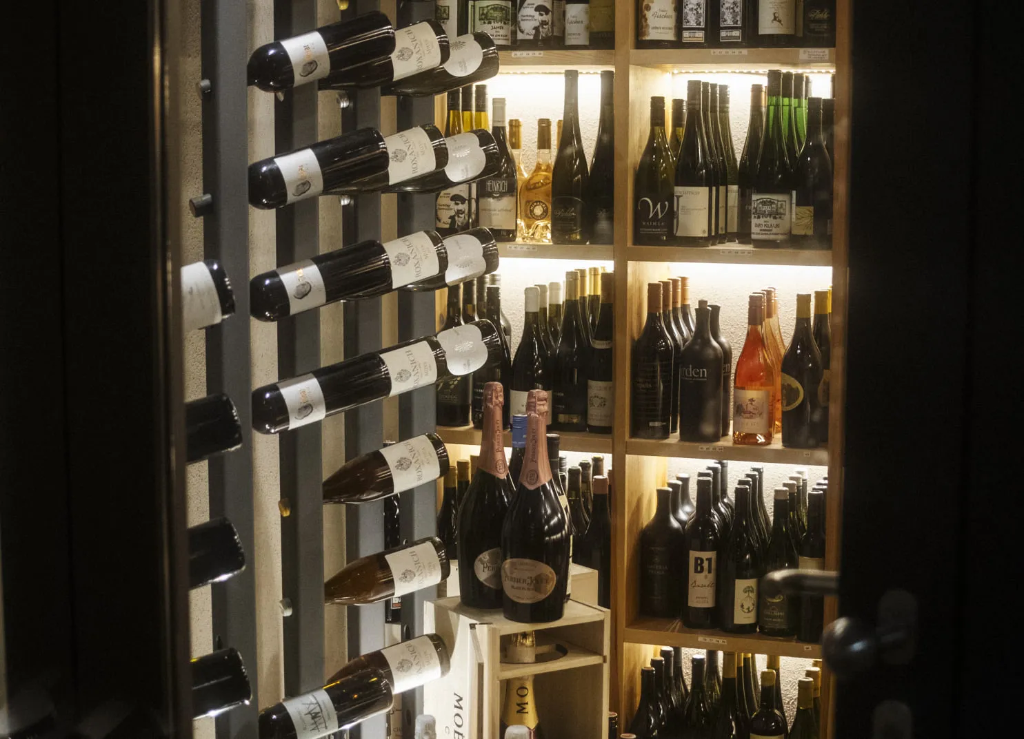 Weinregal mit verschiedenen Weinen im Holzhotel Forsthofalm, Leogang