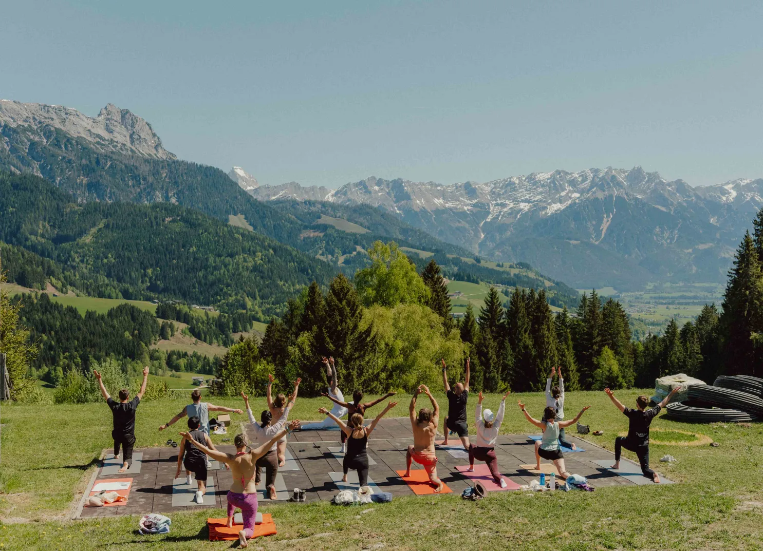 Gruppenyoga im Freien mit Bergen im Hintergrund