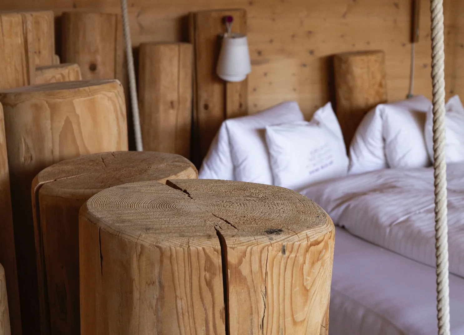 Holzstämme und Betten in einem rustikalen Innenraum