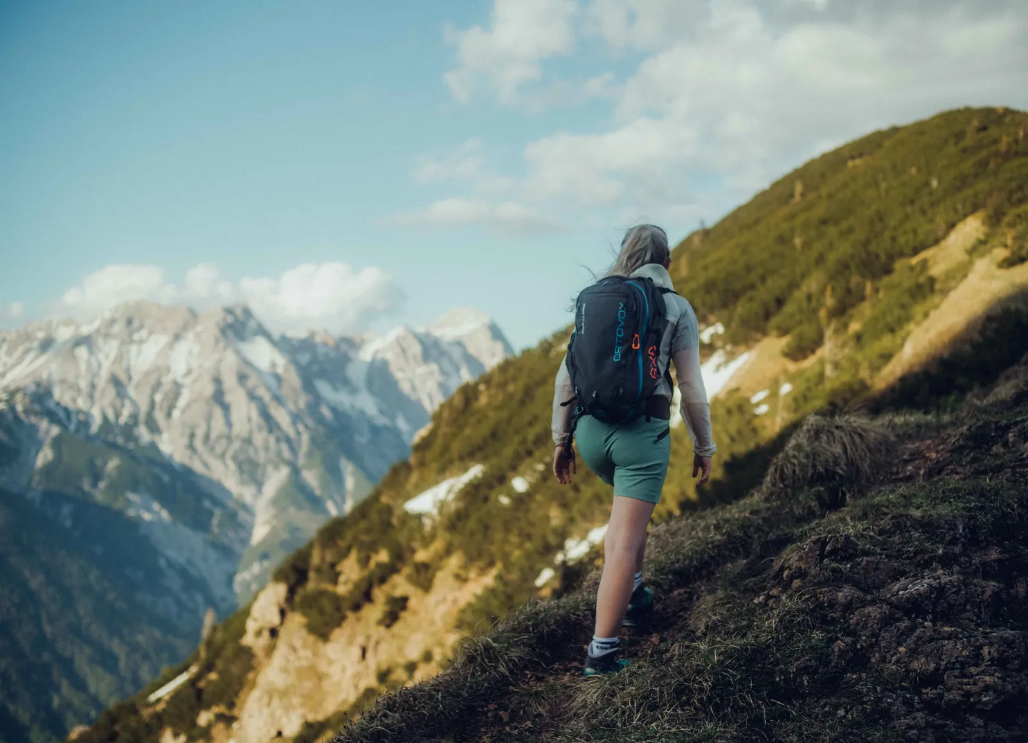 Wanderer mit Rucksack erkundet einen Bergpfad in den Alpen.