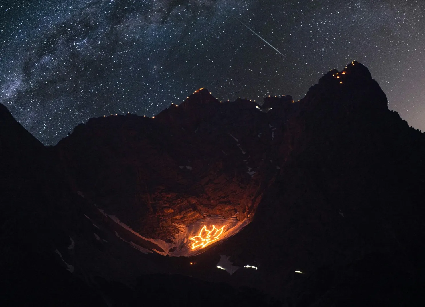 Leuchtende Feuer auf einem Berg unter einem sternenklaren Himmel