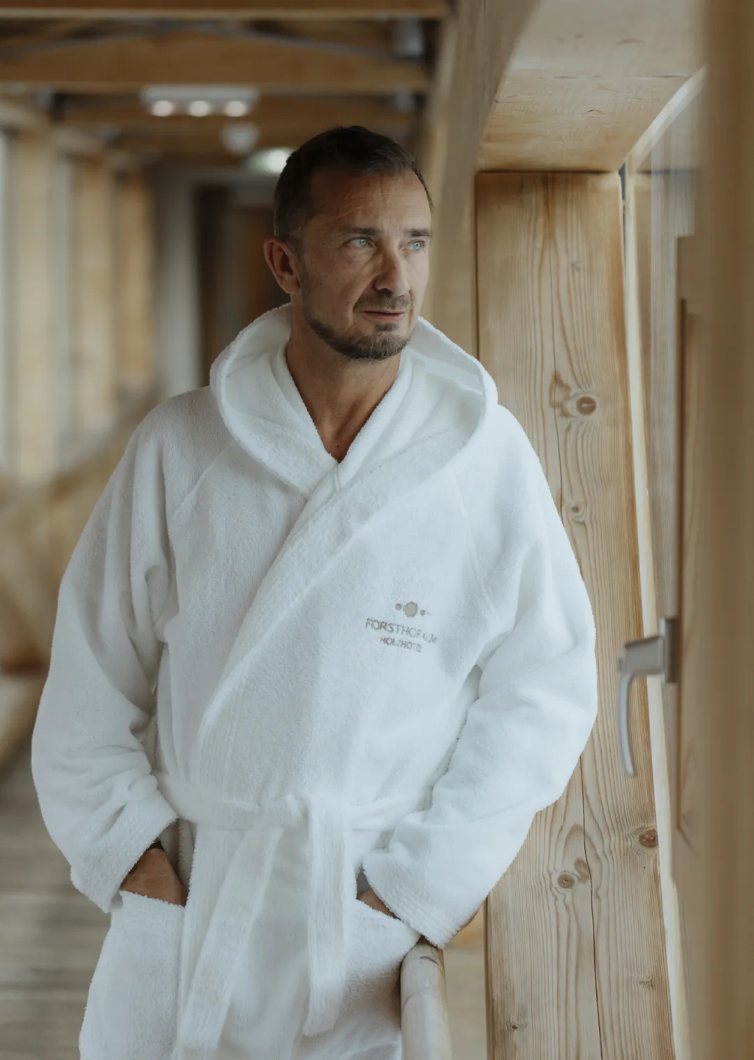 Man in bathrobe stands in Forsthof Sauna.