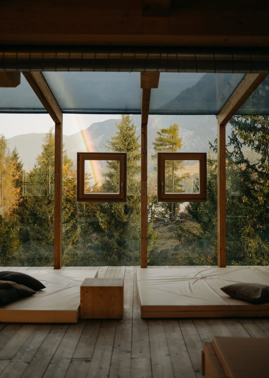 Holzhütte mit Panoramafenstern und Blick auf Bäume