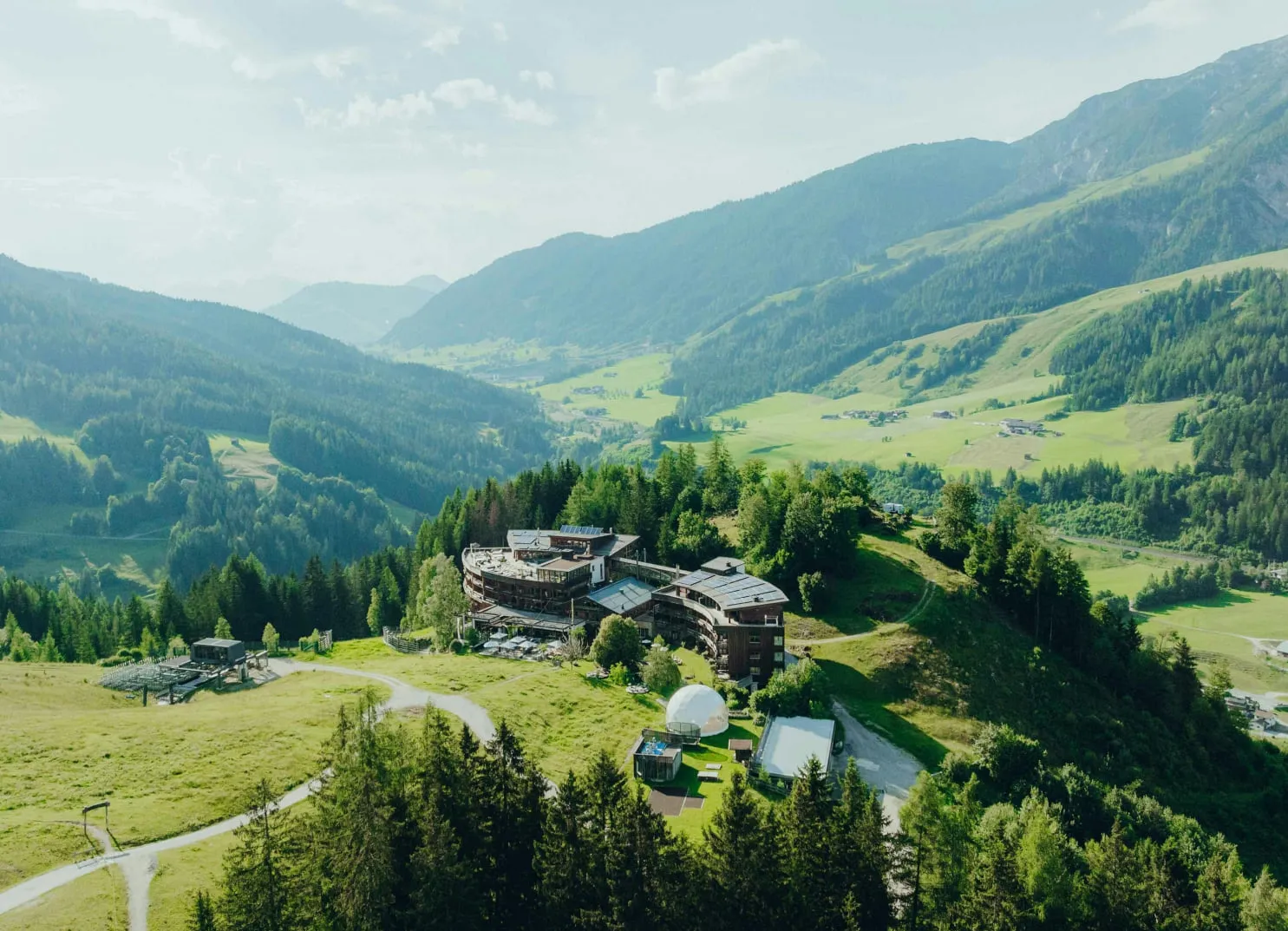 Luftaufnahme eines Bergtals mit Gebäuden und Bäumen